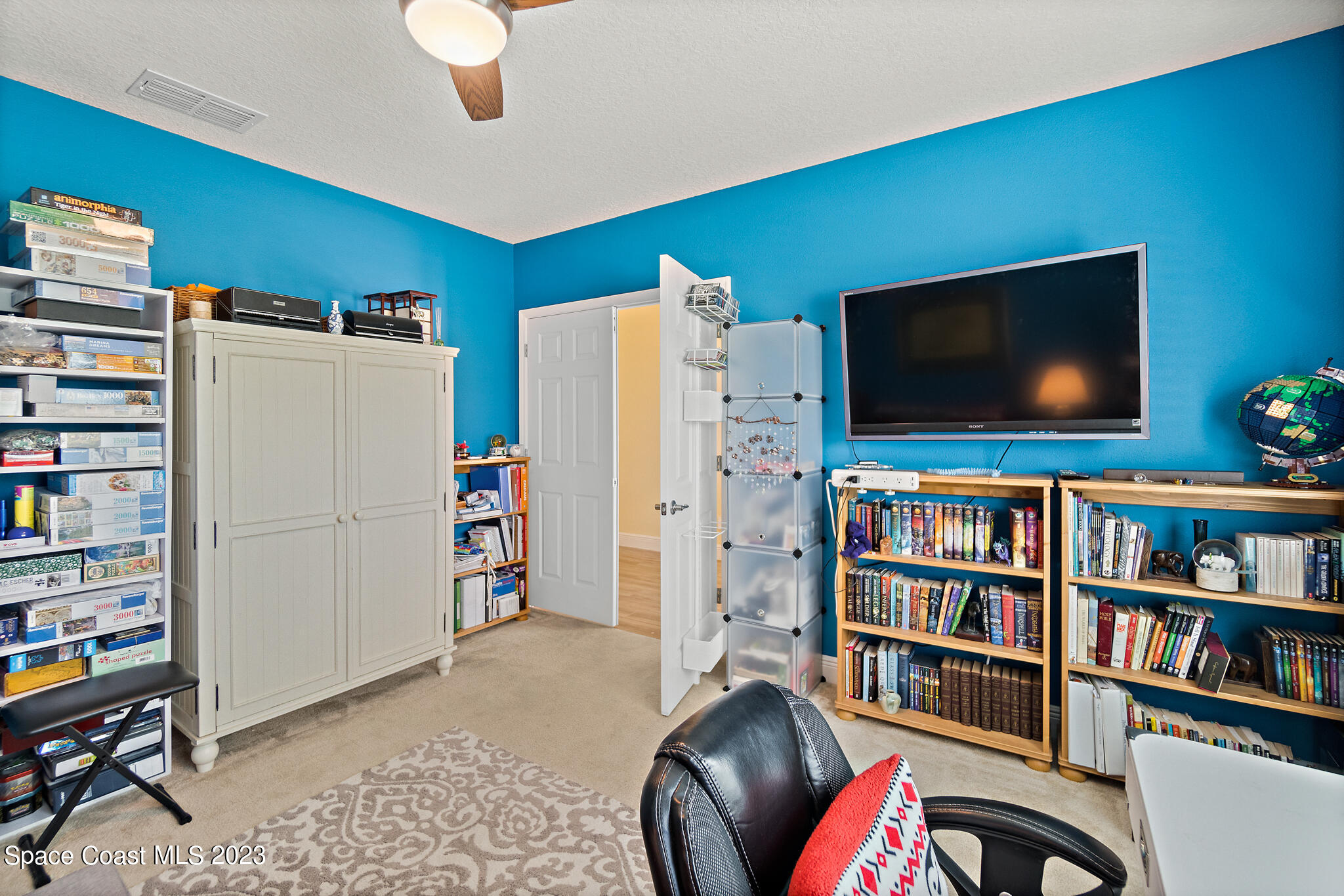 4465 Ruthann Circle Melbourne, FL 32934 - Photo 25 of 42 a living room with furniture and a flat screen tv