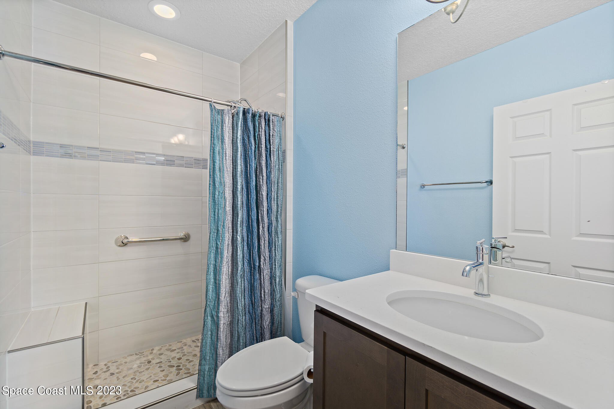 4465 Ruthann Circle Melbourne, FL 32934 - Photo 26 of 42 a bathroom with a sink a toilet a mirror and shower