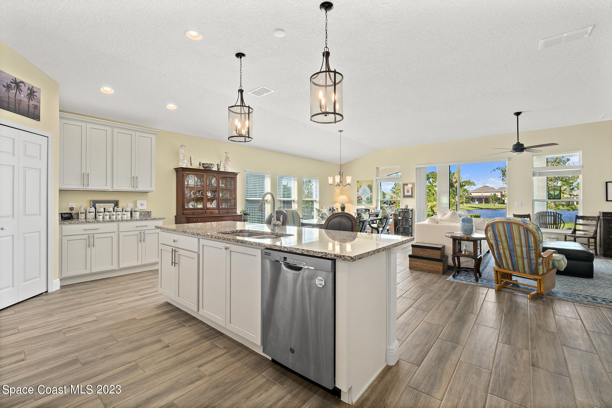 4465 Ruthann Circle Melbourne, FL 32934 - Photo 9 of 42 a kitchen with stainless steel appliances granite countertop wooden floors and white cabinets