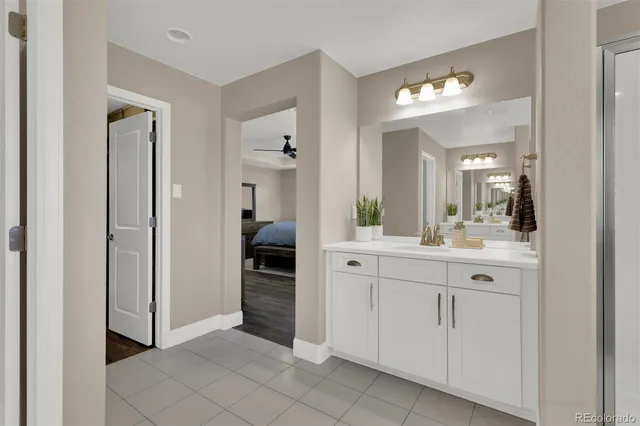 a spacious en suite bathroom with a sink and a mirror