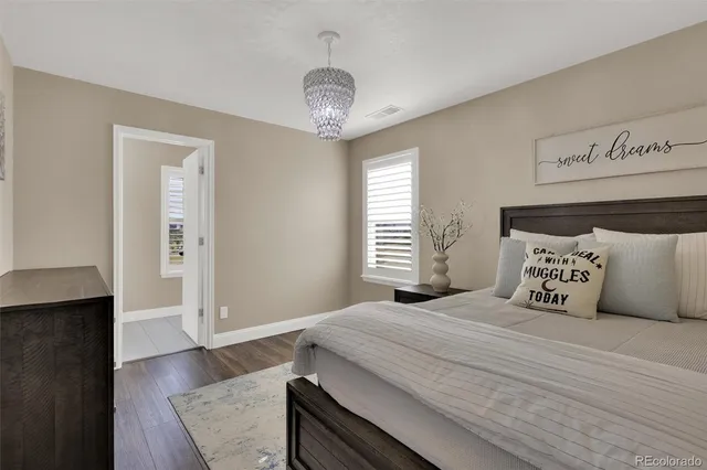 a bedroom with a large bed and a chandelier