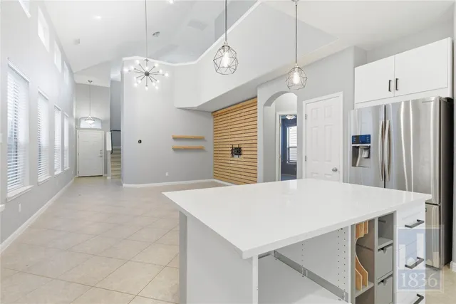 a large kitchen with stainless steel appliances a refrigerator a sink and a stove