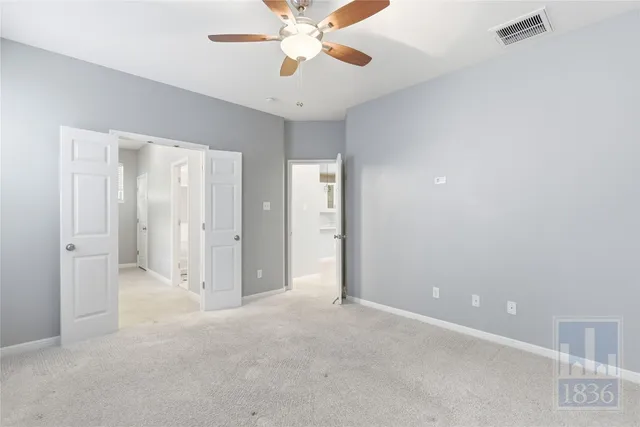 an empty room with closet and a chandelier fan