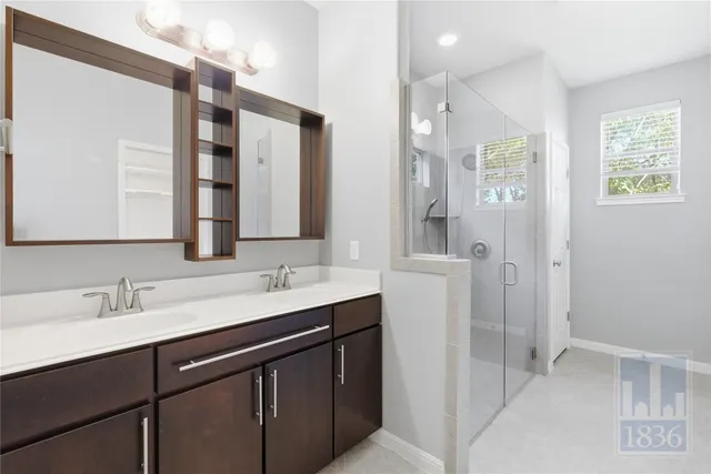 a bathroom with a double vanity sink a mirror and a shower