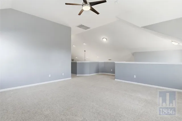 an empty room with view of ceiling fan and windows