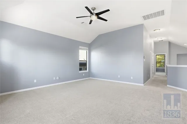 an empty room with fan and windows