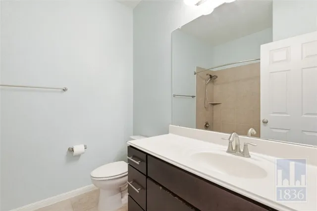 a bathroom with a sink a toilet a mirror and shower