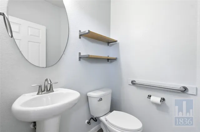 a bathroom with a sink a toilet and mirror