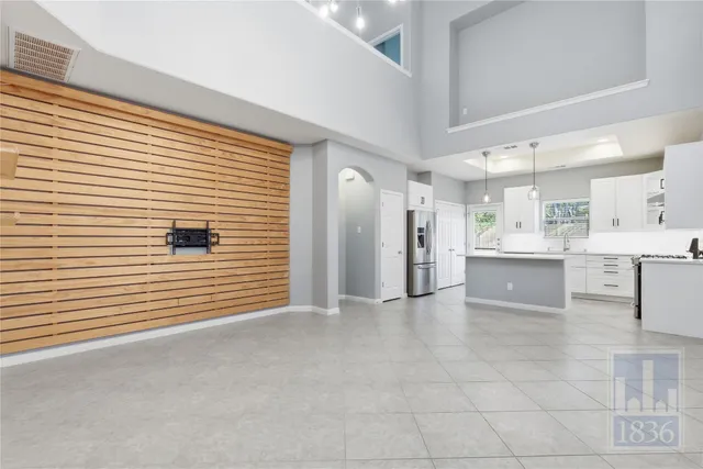 a large white kitchen with granite countertop lots of white cabinets a sink and stainless steel appliances