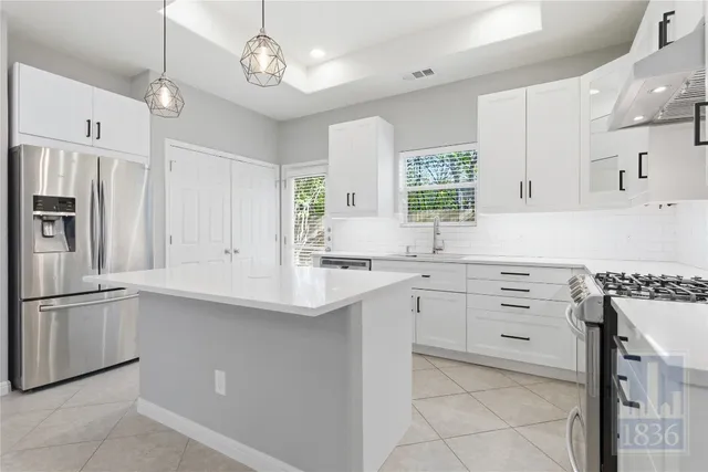 a kitchen with cabinets a sink stainless steel appliances and window