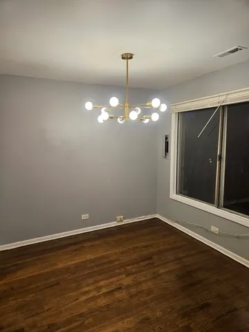 a view of a room with wooden floor and chandelier
