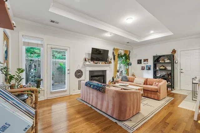 a living room with furniture a fireplace a flat screen tv and a large window