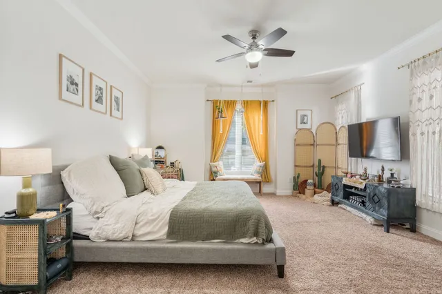 a spacious bedroom with a bed a couch and a chandelier