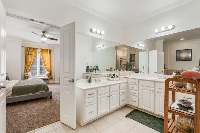 a large white bathroom with a double vanity sink a mirror and a bathtub