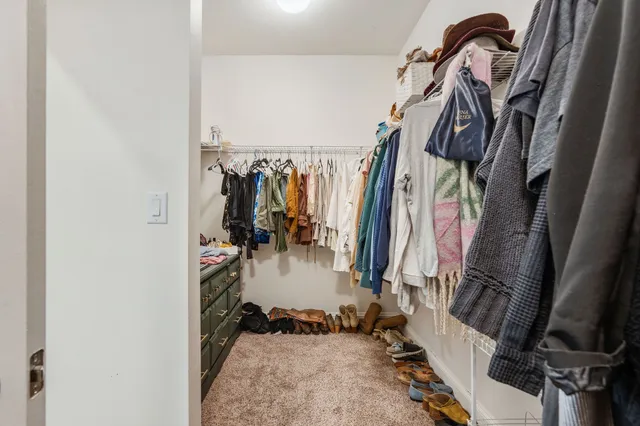 a view of walk in closet with clothes and shoes