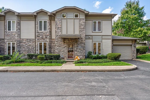 a front view of a house with a yard and trees