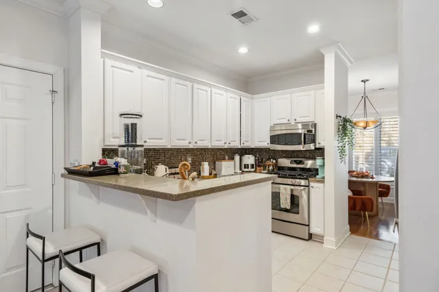 a kitchen with stainless steel appliances a stove top oven a refrigerator and cabinets