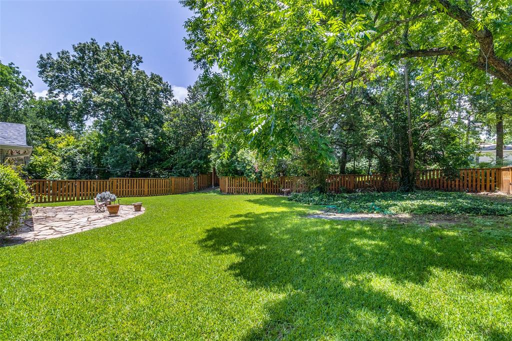 800 Harter Road Dallas, TX 75218 - Photo 15 of 17 Fenced backyard featuring a patio and view of wooded area
