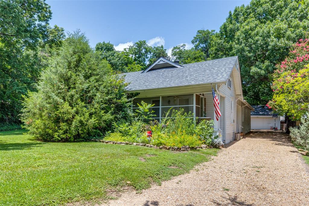 800 Harter Road Dallas, TX 75218 - Photo 8 of 17 View of property exterior with a shingled roof, an outdoor structure, a yard, and a garage