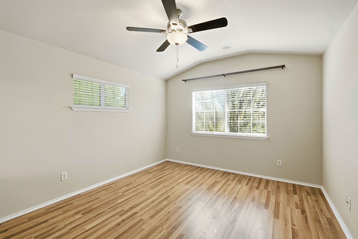 1900 Scofield Ridge Parkway, Unit 203 Austin, TX 78727 - Photo 14 of 31 Unfurnished room featuring vaulted ceiling, light wood finished floors, healthy amount of natural light, and ceiling fan
