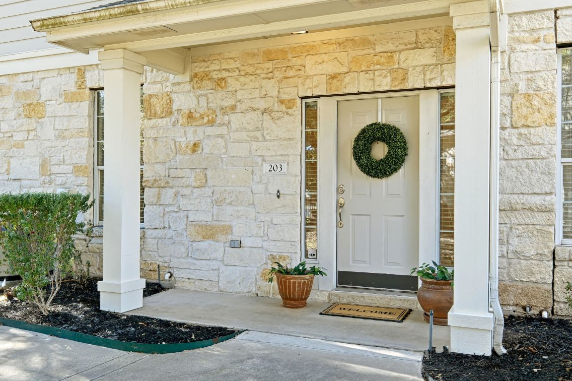 1900 Scofield Ridge Parkway, Unit 203 Austin, TX 78727 - Photo 3 of 31 View of exterior entry with stone siding and a porch