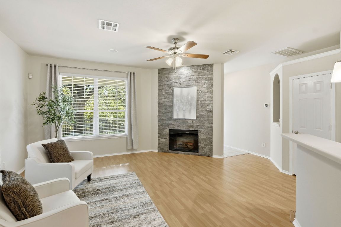 1900 Scofield Ridge Parkway, Unit 203 Austin, TX 78727 - Photo 4 of 31 Living room with ceiling fan, a large fireplace, light wood-style floors, and arched walkways