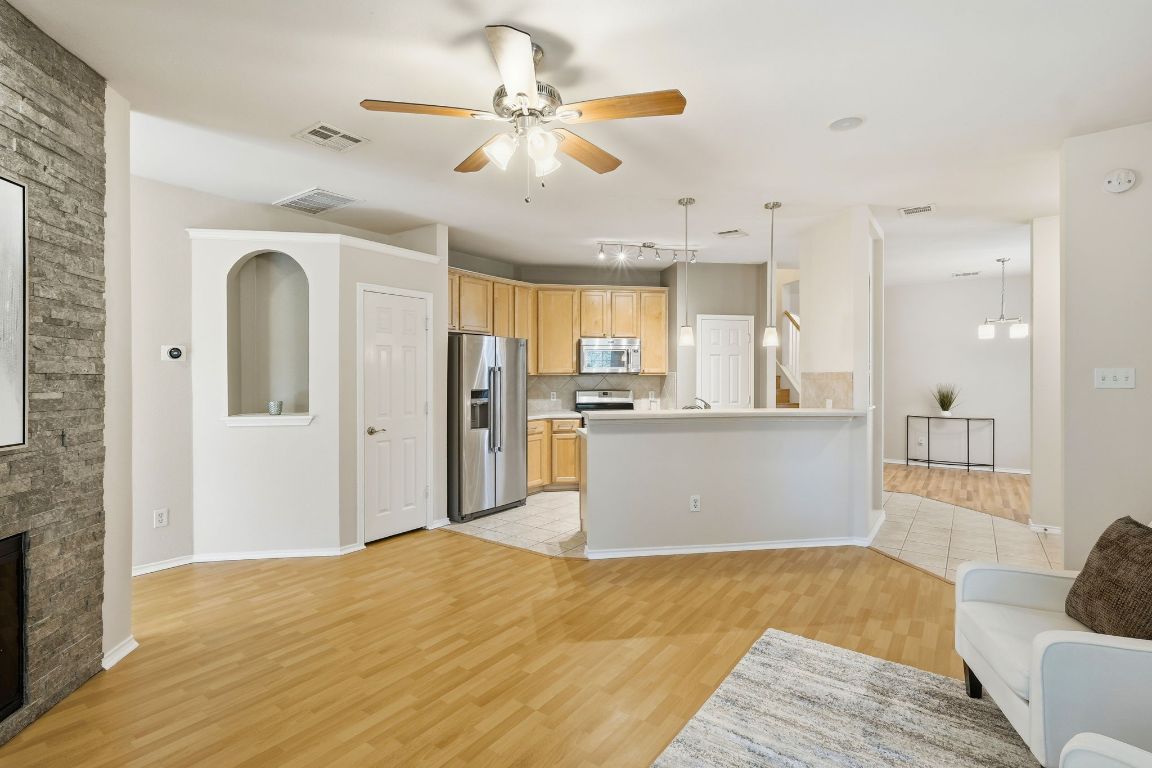 1900 Scofield Ridge Parkway, Unit 203 Austin, TX 78727 - Photo 6 of 31 Living room with ceiling fan, light wood finished floors, and a stone fireplace