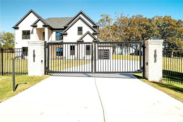 a view of a white house with wooden fence