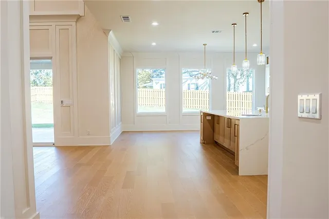 a kitchen with stainless steel appliances granite countertop a stove a sink and white cabinets with wooden floor