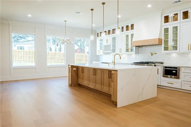 a large kitchen with stainless steel appliances kitchen island granite countertop a stove a sink a refrigerator and a granite counter tops