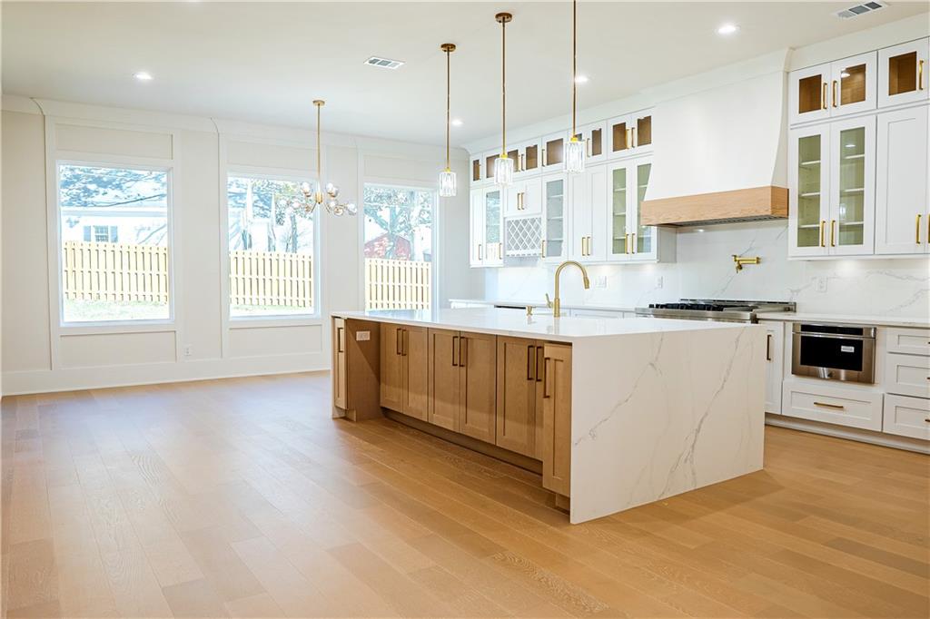 2210 Ridgedale Drive Southwest Grayson, GA 30017 - Photo 4 of 74 a kitchen with stainless steel appliances granite countertop a stove a sink and white cabinets with wooden floor