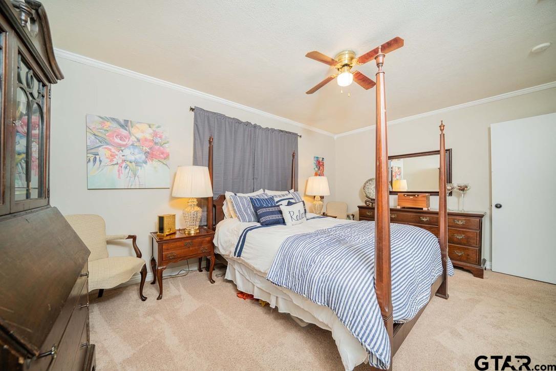 607 Green Oak Drive Longview, TX 75604 - Photo 14 of 48 a bedroom with a bed and a chandelier