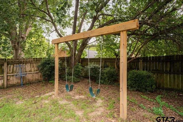 a view of a house with a yard and a large tree