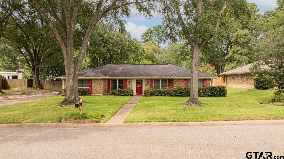 607 Green Oak Drive Longview, TX 75604 - Photo 40 of 48 a front view of a house with a garden and trees