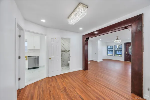 a view of a big room with wooden floor and a kitchen