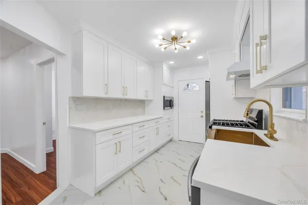 a kitchen that has a lot of cabinets and wooden floor