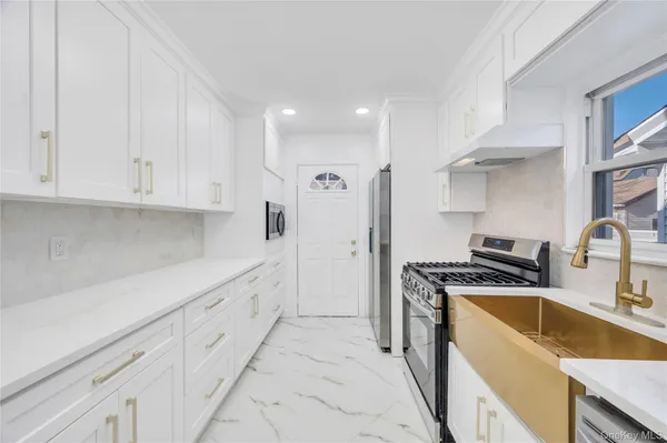 a kitchen with granite countertop a sink stove and refrigerator