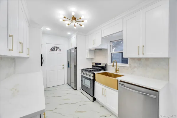 a kitchen with stainless steel appliances granite countertop a sink a stove and refrigerator