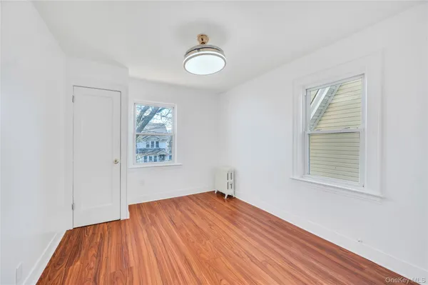 an empty room with a hardwood and ceiling fan