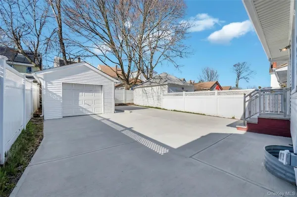 a view of a white house with a yard and garage
