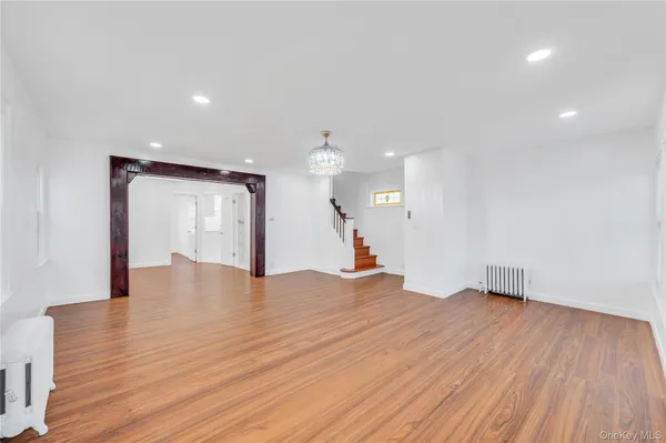 a view of empty room with wooden floor and ceiling fan