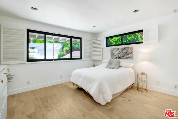 a bedroom with a large bed and a chandelier