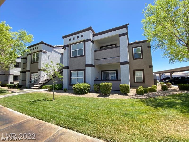 7255 West Sunset Road, Unit 2052 Las Vegas, NV 89113 - Photo 1 of 16 Contemporary apartment complex featuring a mix of stucco and block construction, with lush green landscaping.