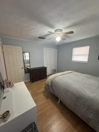 a spacious bedroom with a bed and a chandelier