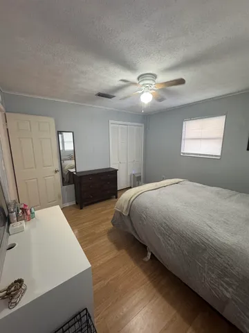 a spacious bedroom with a bed and a chandelier