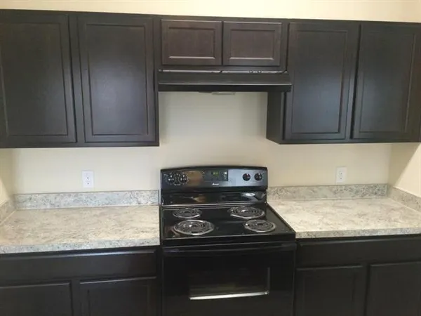 a stove top oven sitting inside of a kitchen