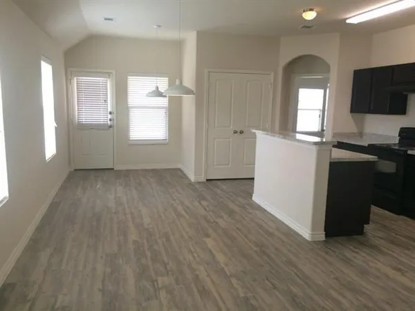 a view of a room with wooden floor and furniture