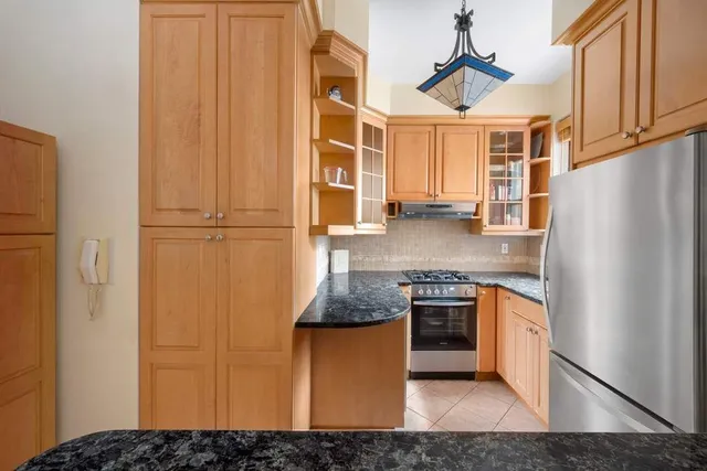 a kitchen with stainless steel appliances granite countertop a refrigerator a stove and a sink