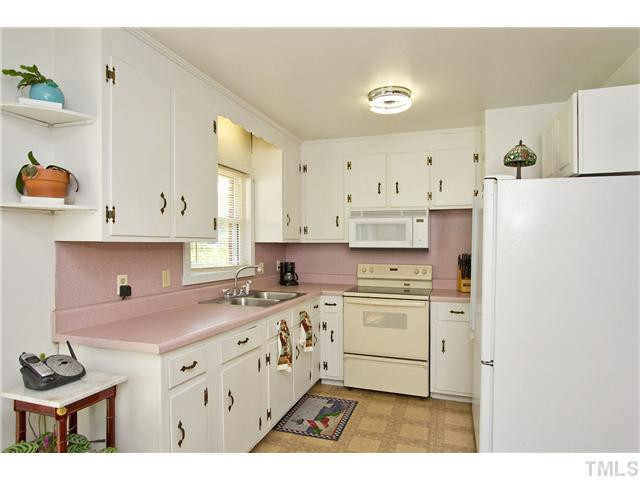 222 Santee Road Durham, NC 27704 - Photo 4 of 21 a kitchen with kitchen island a sink a stove and a refrigerator