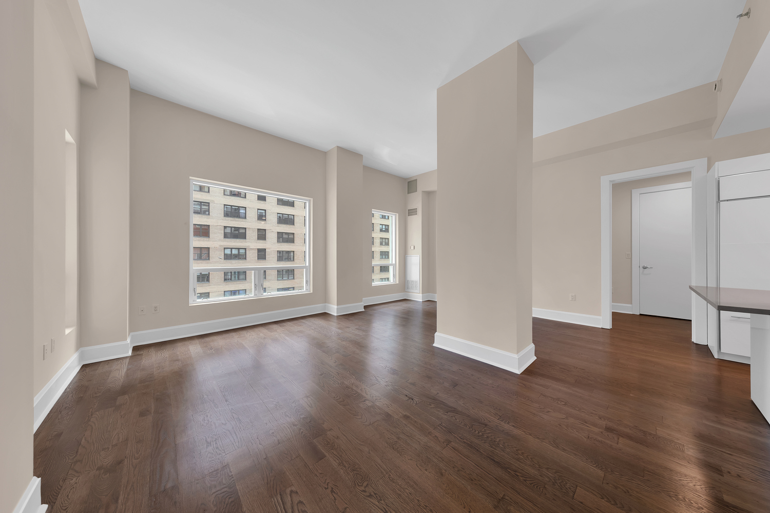250 East 49th Street, Unit 3E Manhattan, NY 10017 - Photo 2 of 20 a view of an empty room with wooden floor and windows